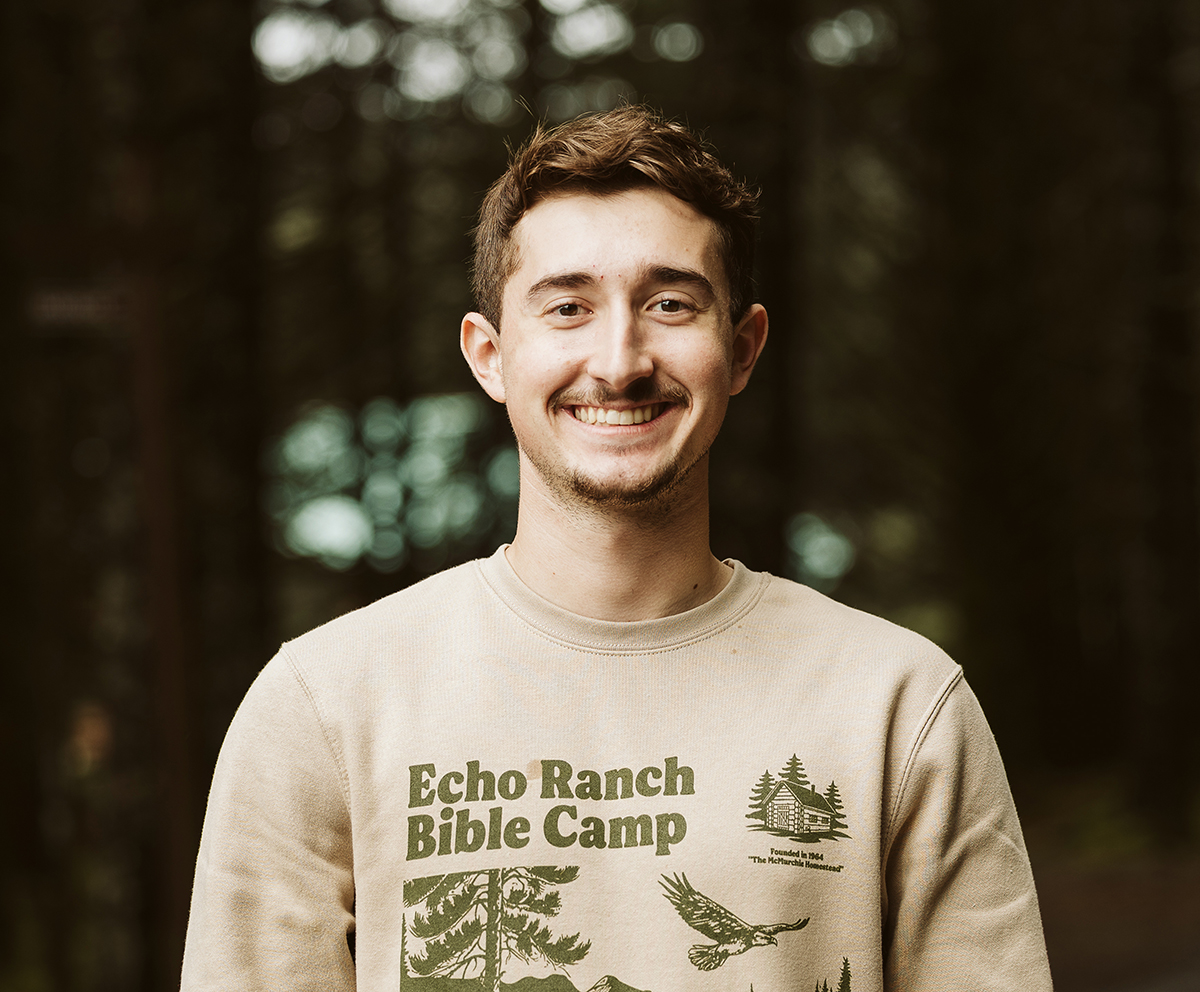 Evan smiling wearing an Echo Ranch Bible Camp sweatshirt.